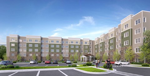 A large apartment complex with a parking lot in front.