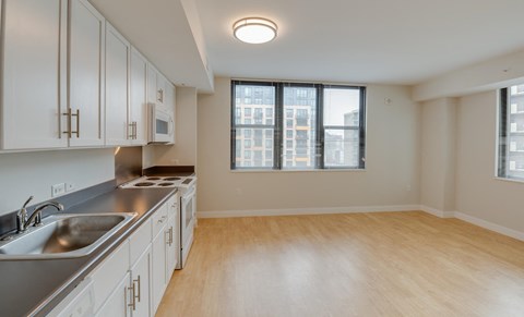 a kitchen with white cabinets and a sink and a window