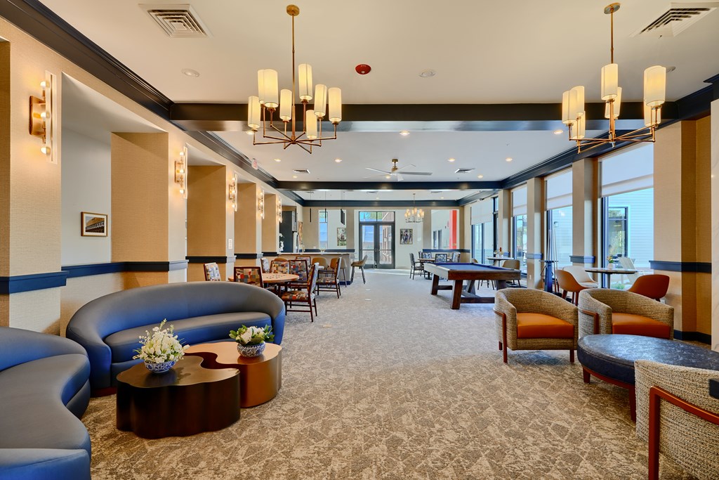 Now leasing senior 1-bedrooms in Baltimore, MD. A large room with a carpeted floor and a long table with chairs.