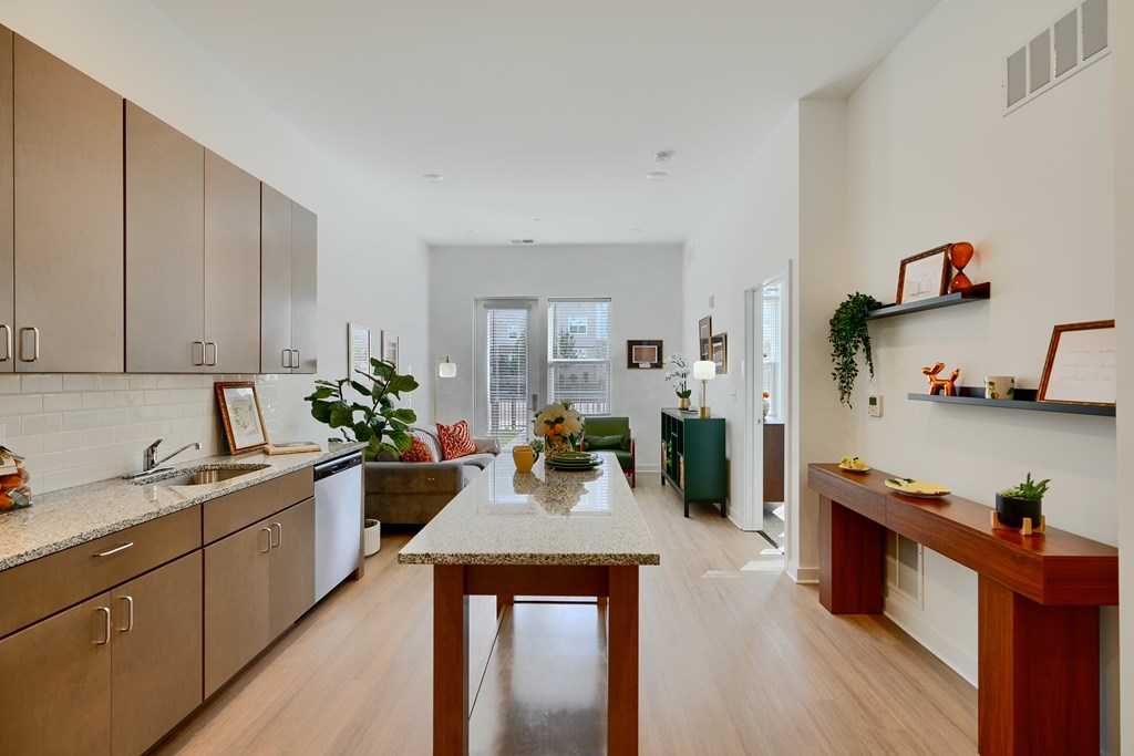 Now leasing senior 1-bedrooms in Baltimore, MD. A kitchen with wooden cabinets and a table in the middle.