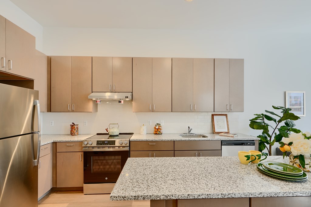Now leasing senior 1-bedrooms in Baltimore, MD. A kitchen with a refrigerator, oven, and sink.