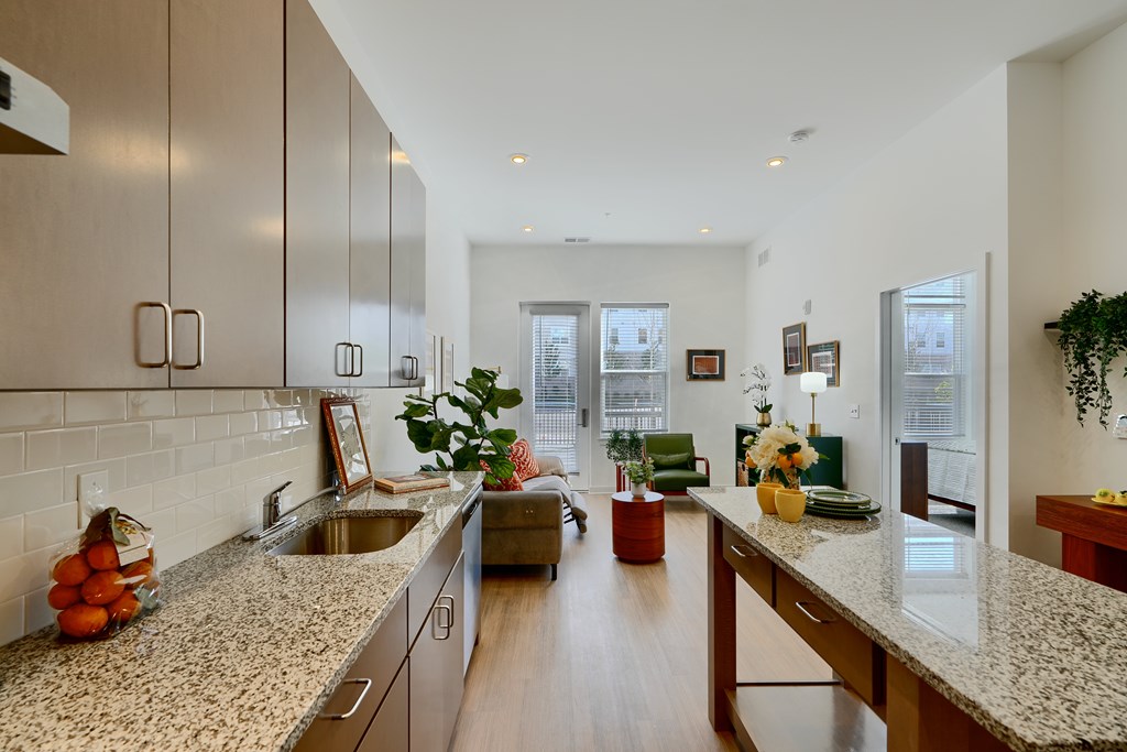 Now leasing senior 1-bedrooms in Baltimore, MD. A kitchen with a granite countertop and wooden cabinets.