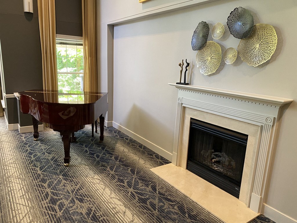 a living room with a piano and a fireplace