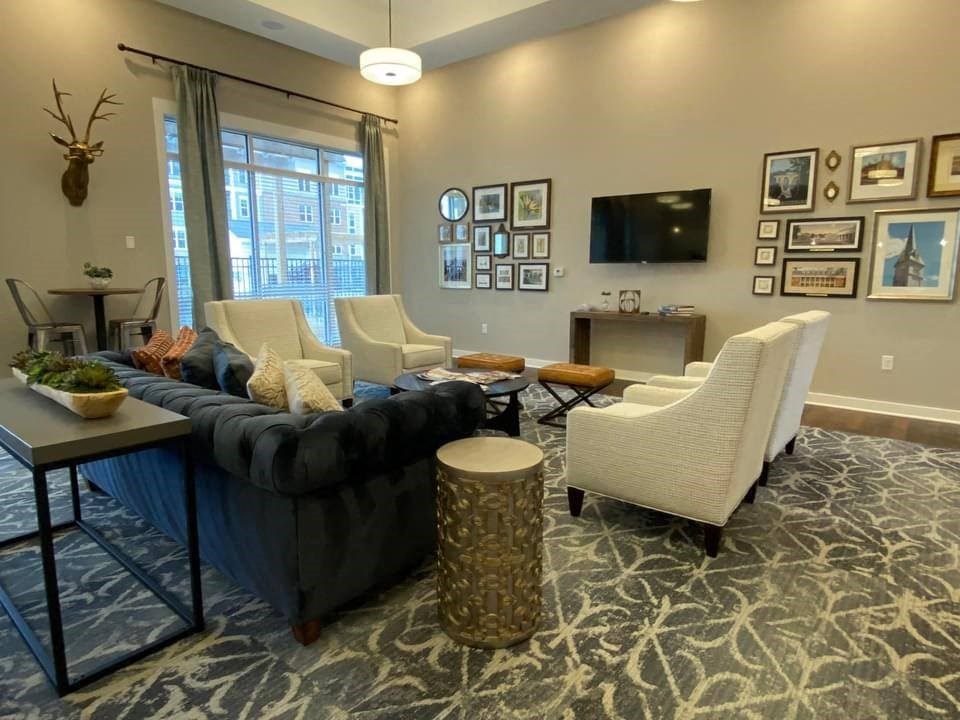 a living room with a couch and chairs and a television