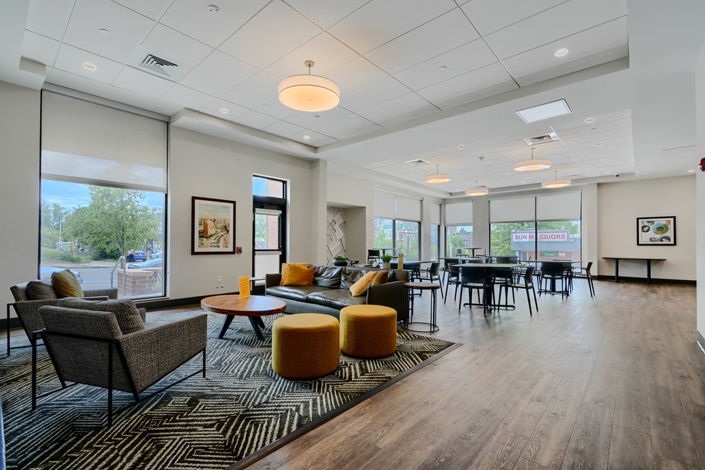 A spacious waiting area with a variety of seating options and a view of the outdoors through large windows.
