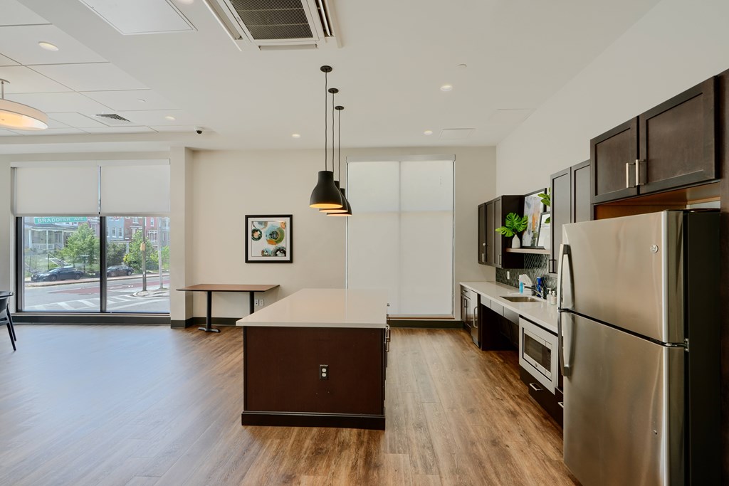 A modern kitchen with stainless steel appliances and wooden floors.
