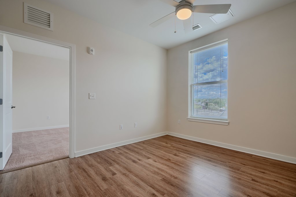 A room with a ceiling fan and a window.