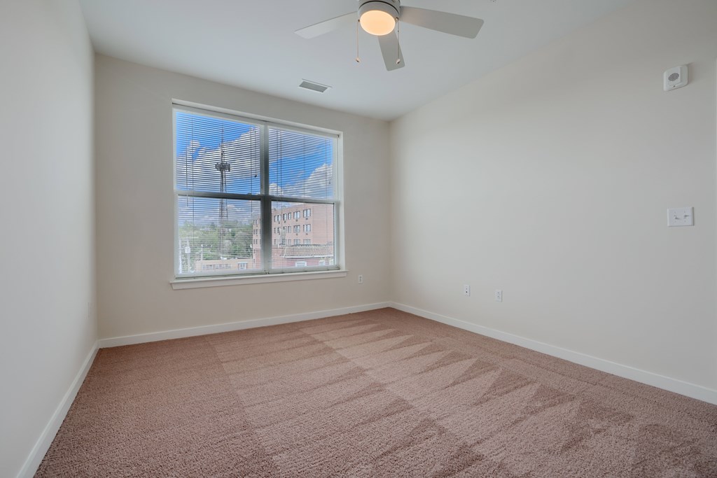 A room with a window and a ceiling fan.