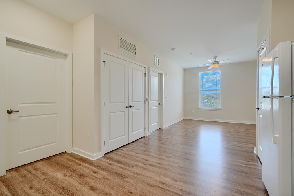 A kitchen with white cabinets and a white fridge.