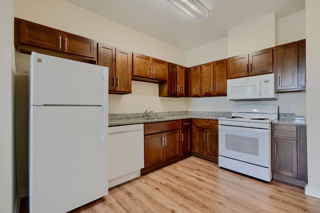 A kitchen with wooden cabinets and white appliances.