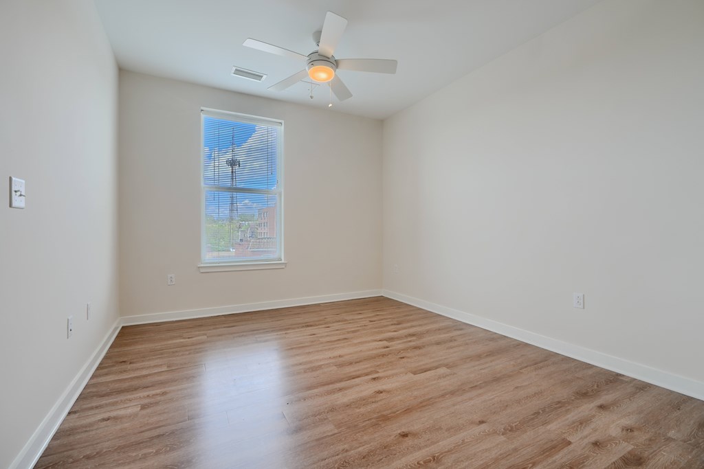 Empty room with a ceiling fan and a window.