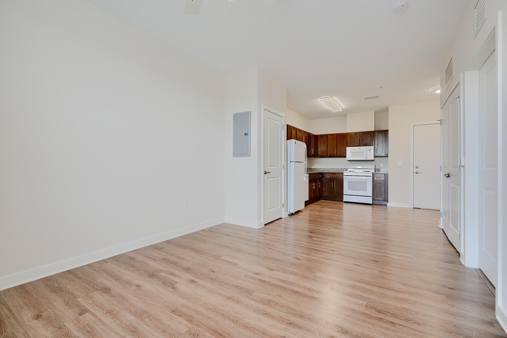 A kitchen area with white cabinets and a wooden countertop.