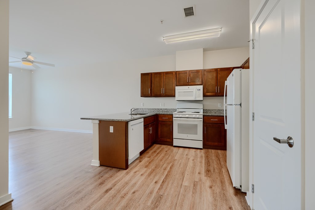 A kitchen with white appliances and wooden cabinets.