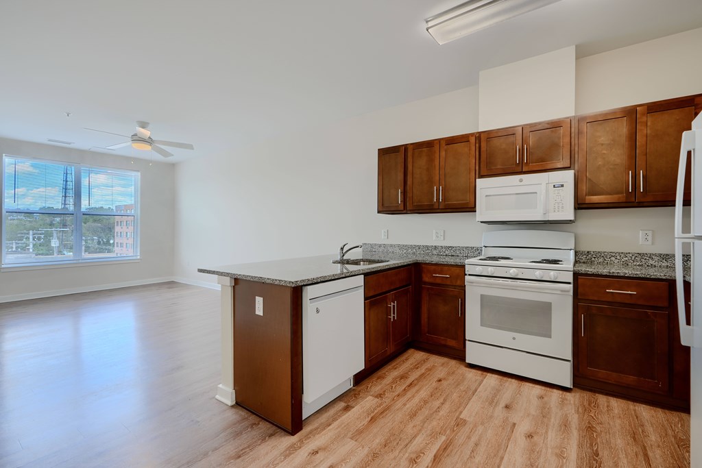 A kitchen with brown cabinets and white appliances.
