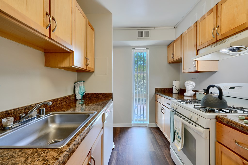 A kitchen with wooden cabinets and a white stove top oven.