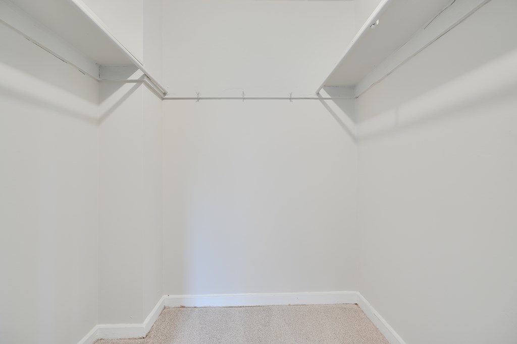 A white room with a carpeted floor and white walls.
