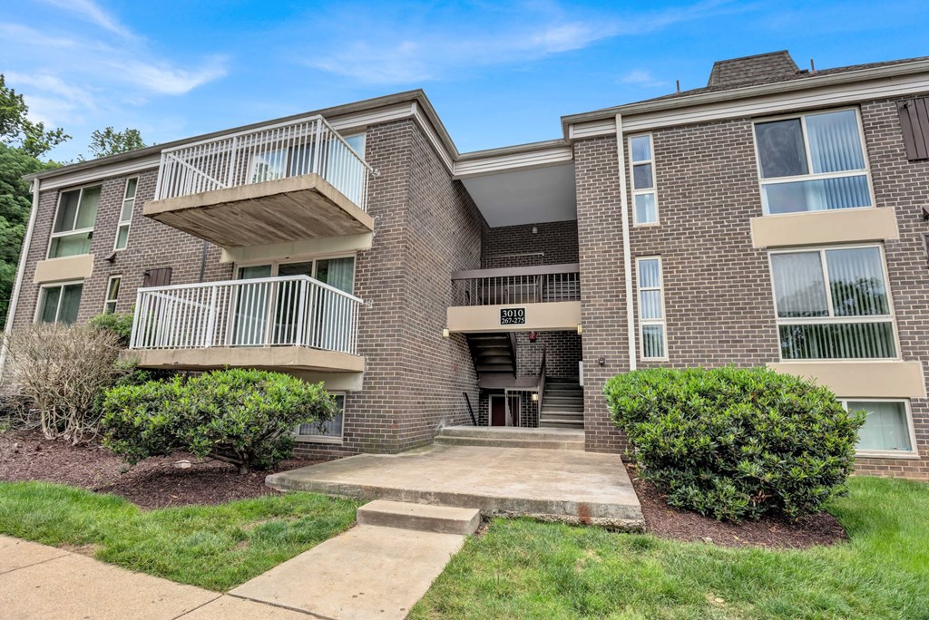 a building with two balconies and a sidewalk in front of it