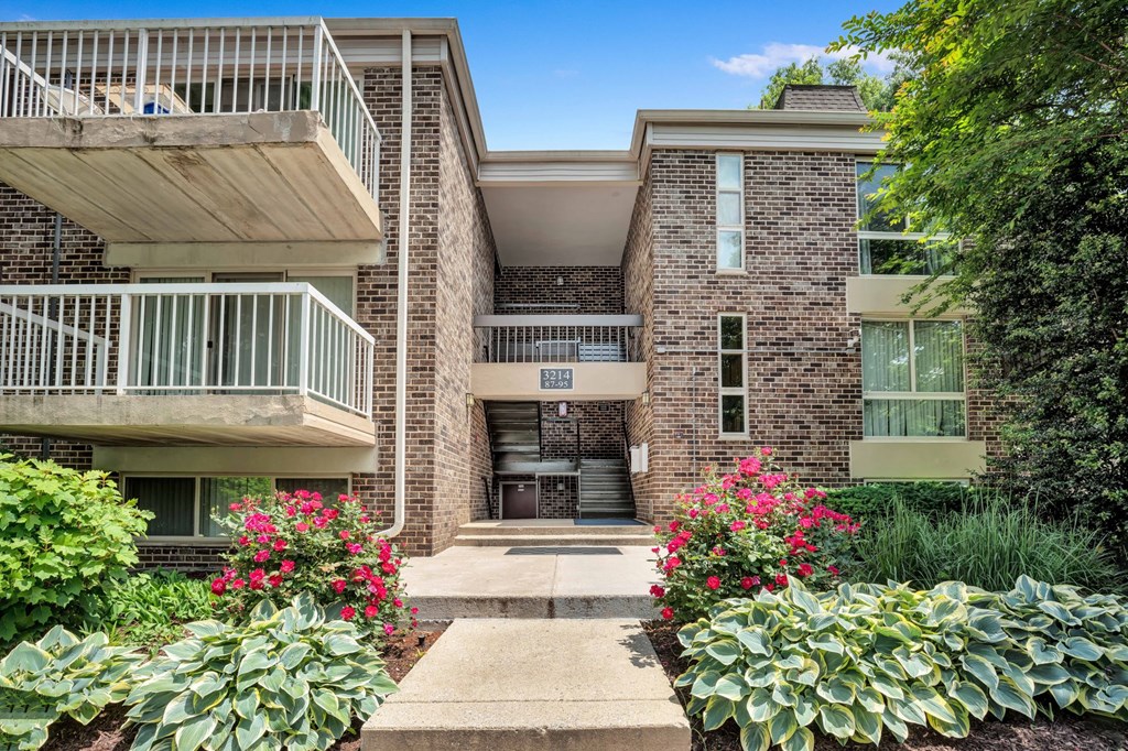 front view of a brick building with plants and flowers