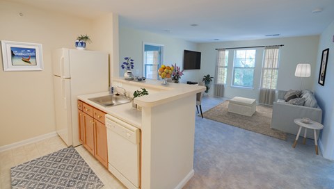 a kitchen and living room with a refrigerator and a sink