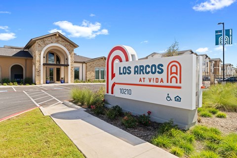 a building with a sign that says los arcos at vida