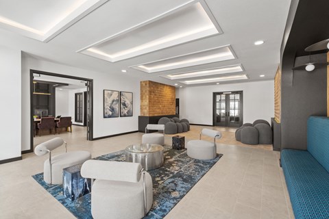 A modern living room with a blue rug and white furniture.