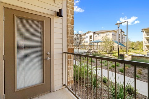 a view from a porch with an apartment in the distance