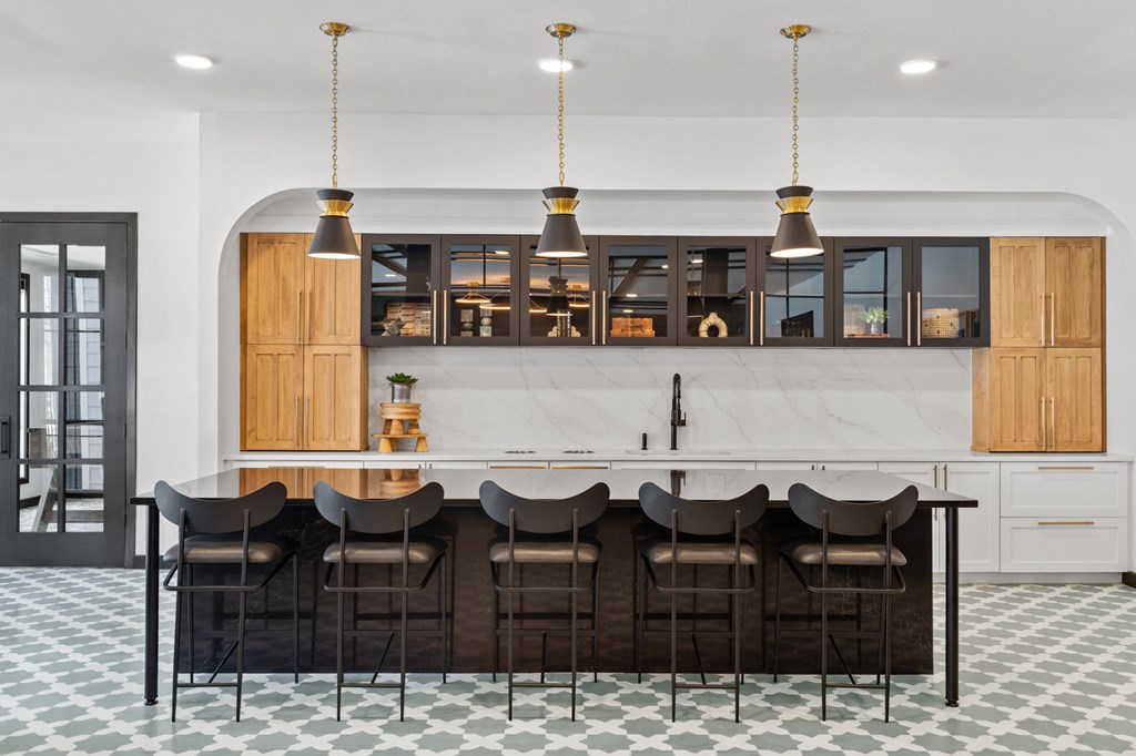 A kitchen with a bar area and chairs.