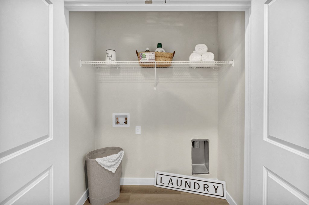 a closet with washer dryer connections and a laundry basket