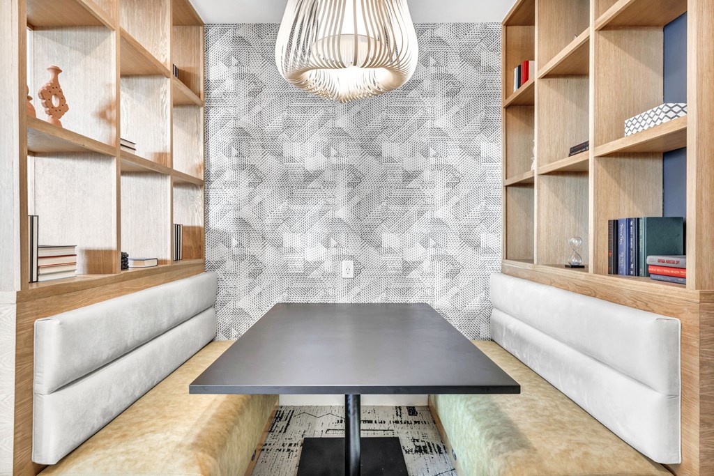 a conference room with a black table and a wall with shelves