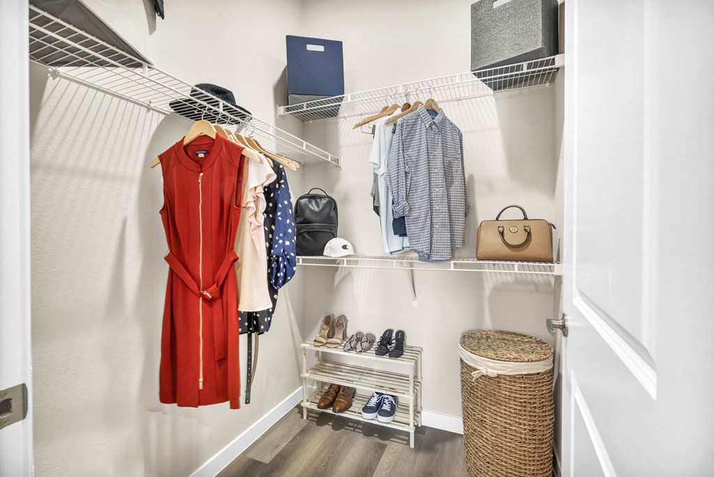 a closet with a rack of clothes and shoes