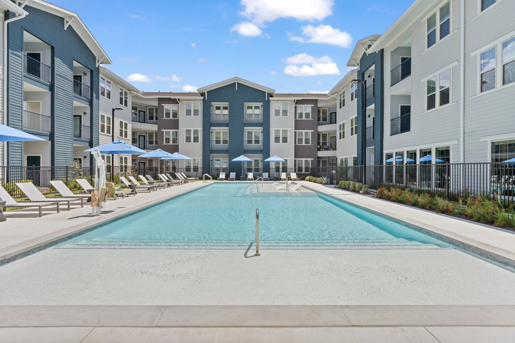 A large swimming pool in front of apartment buildings.