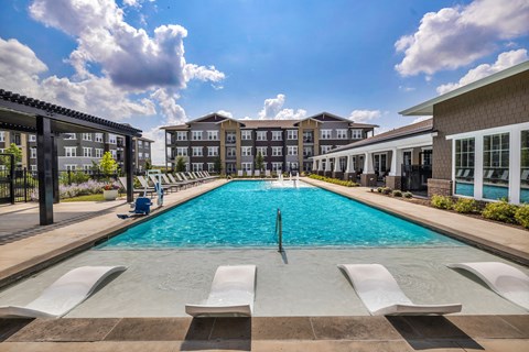 Resort-style swimming pool with comfortable lounge seating and a beautifully maintained outdoor space designed for relaxation.