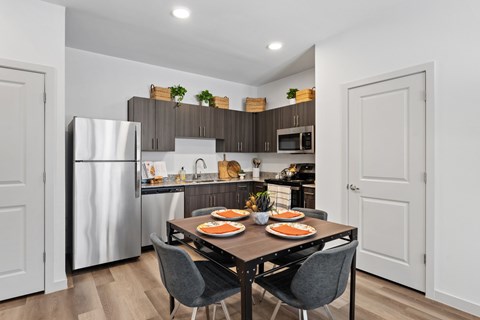 A modern kitchen with a dining table set for two.