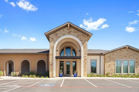 the exterior of a leasing building with a parking lot
