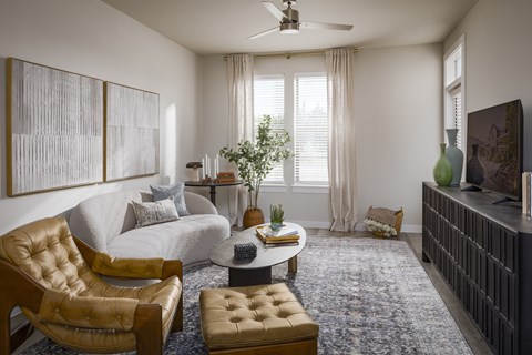 A living room with a brown leather chair and ottoman.