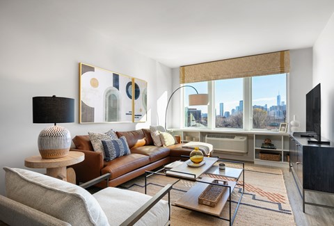 A living room with a brown leather couch and a wooden coffee table.