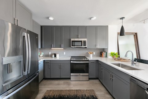 A modern kitchen with a stainless steel refrigerator and a microwave above the stove.