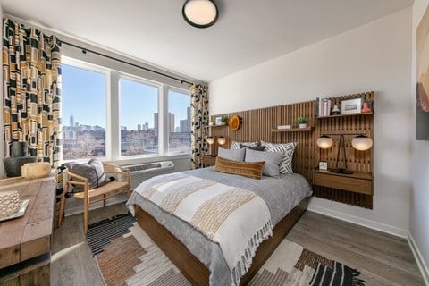 A bedroom with a large bed and a view of the city.