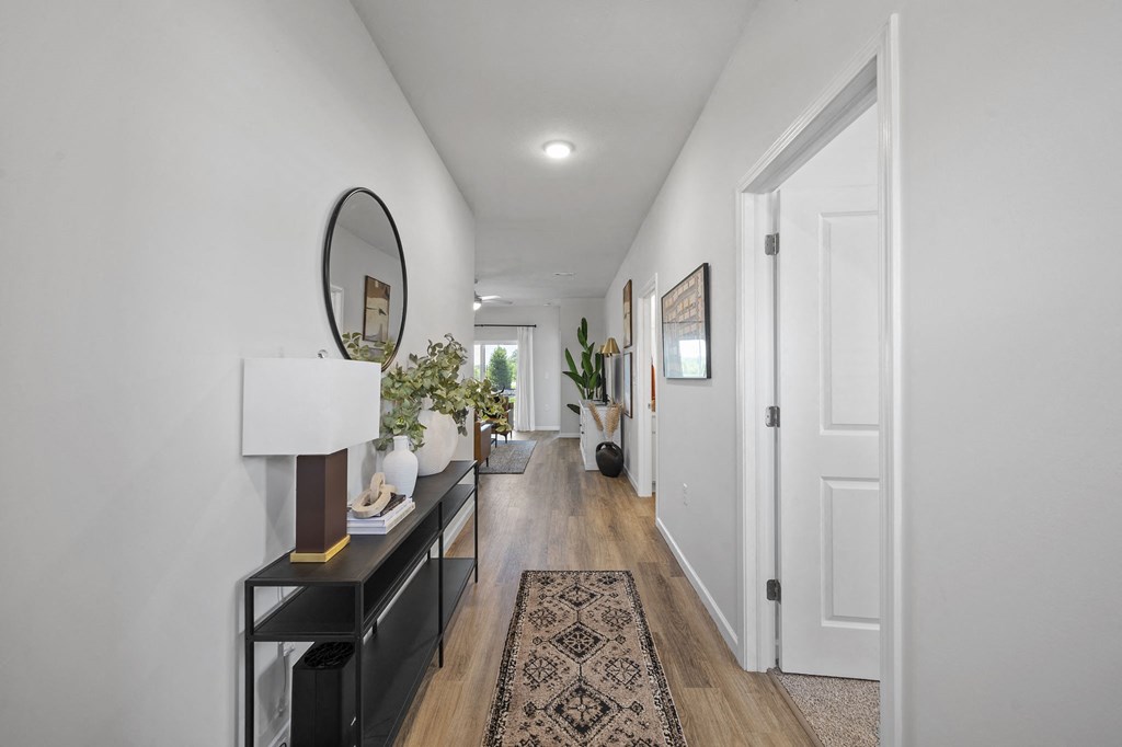a long hallway with white walls and a white door and a mirror