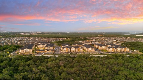 A bird's eye view of a residential area with houses surrounded by greenery.