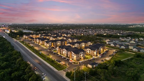 A road with cars and apartment buildings on both sides.