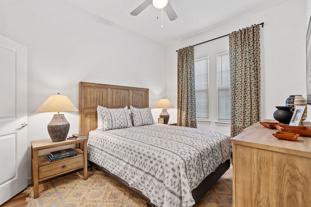 A bedroom with a bed, nightstand, and window.