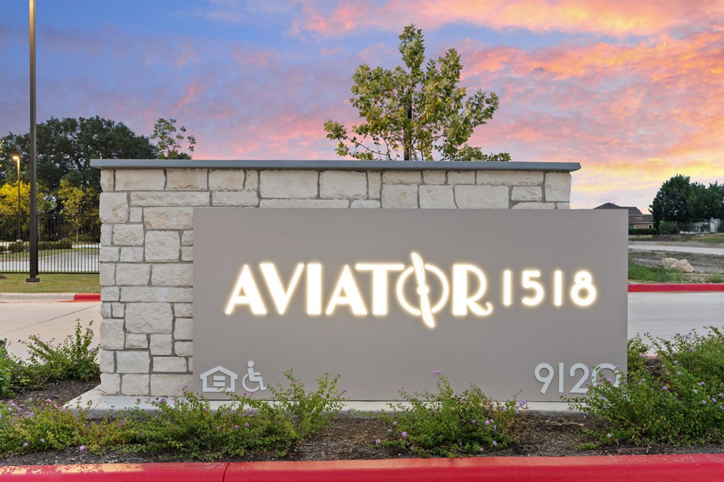 A sign with the text AVIATOR 1518 is displayed in front of a tree.