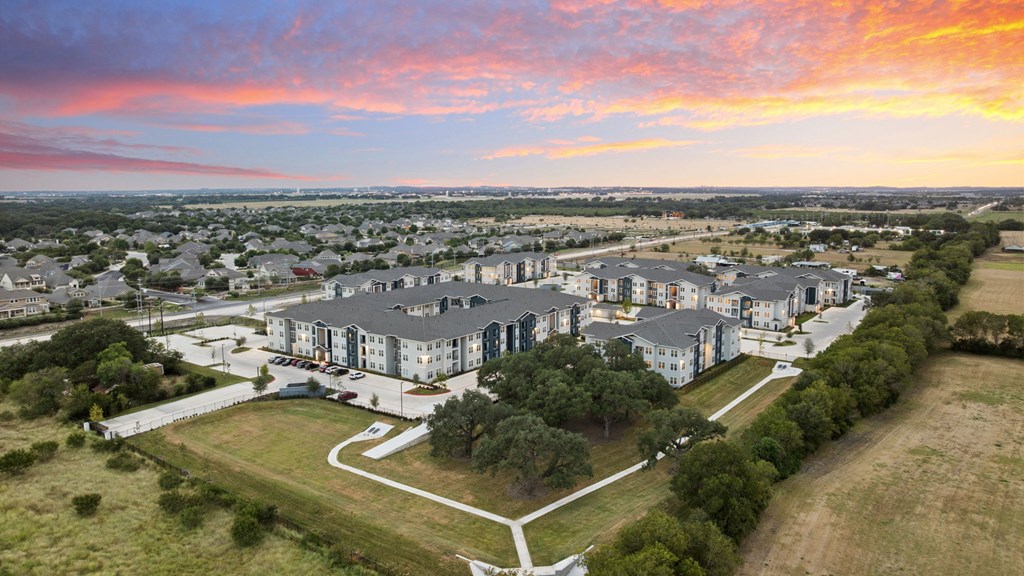 A sunset view of a residential area with houses and apartment buildings.
