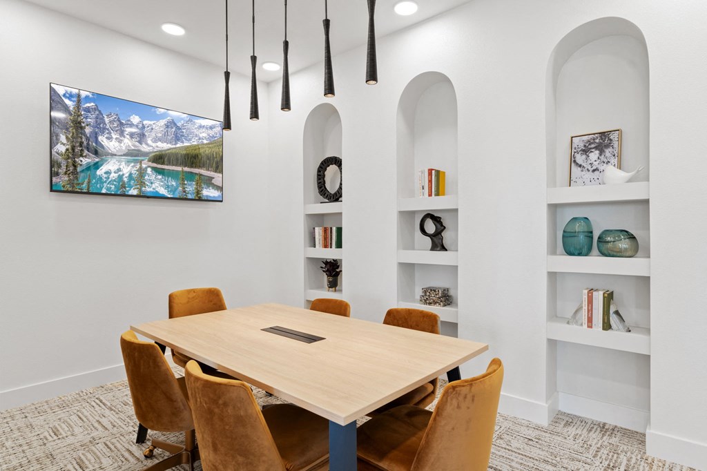 a room with a wooden table and chairs and a tv on the wall