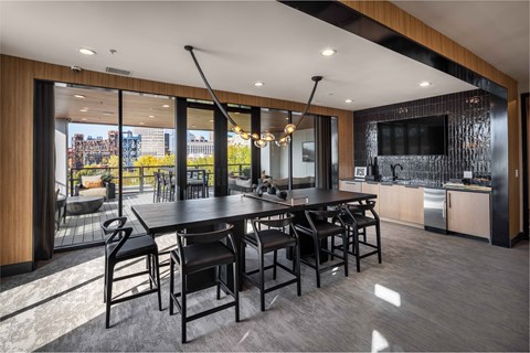 A modern dining room with a large table and chairs.