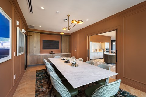 A dining room with a long table and chairs.