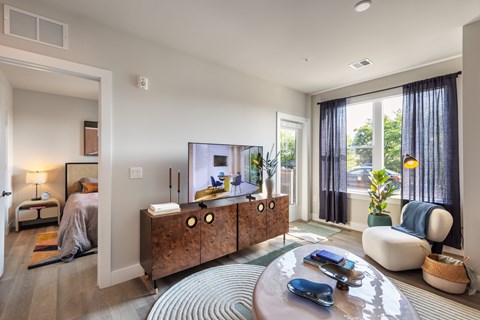 A modern living room with a wooden cabinet and a tv.