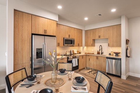 A modern kitchen with a dining table set for two.