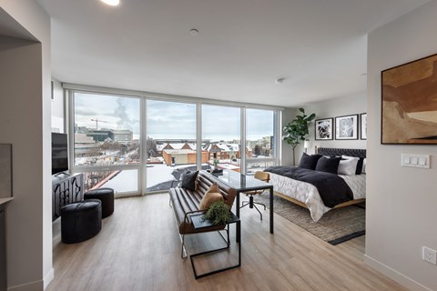 A modern bedroom with a large bed and a view of the city.
